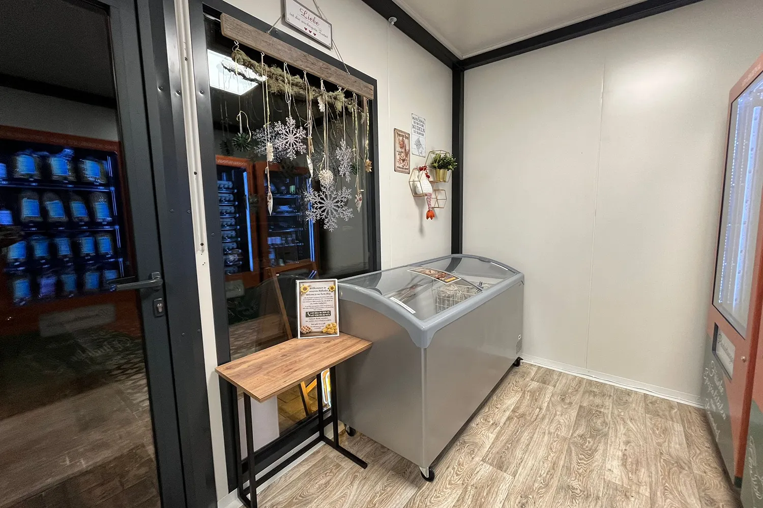 Innenansicht des Hofladens mit Tiefkühltruhe, Selbstbedienungsbereich und liebevoller Dekoration